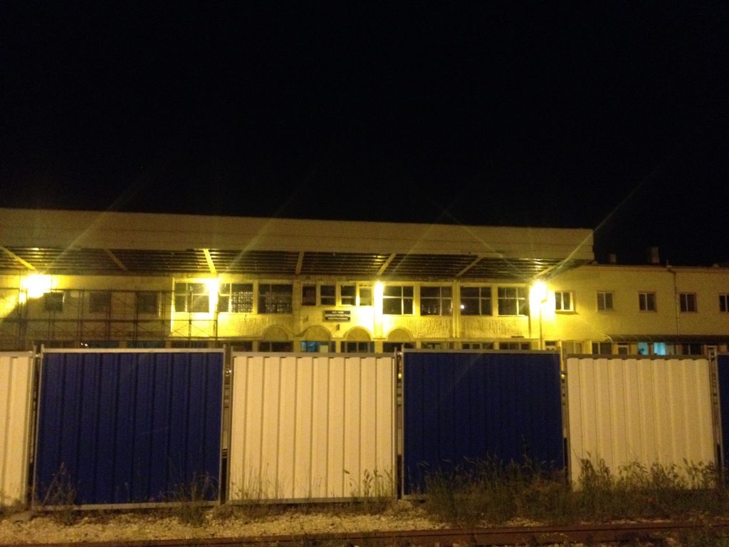 Lights of boarded up Dmitrovgrad station, grass coming through tracks
