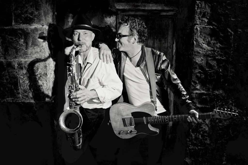 Anto (with saxophone) and Leo with guitar in black and white