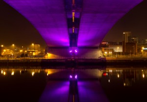 Purple light under Kingston Bridge reflecting with street lights in the Clyde