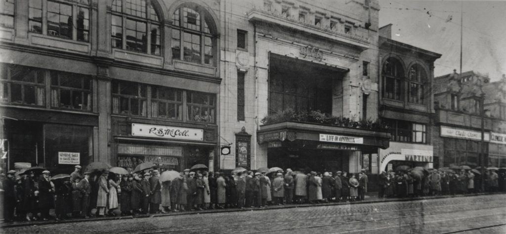 A black and white image of a long queue outside the Regal cinema in Sauchiehall Street. 