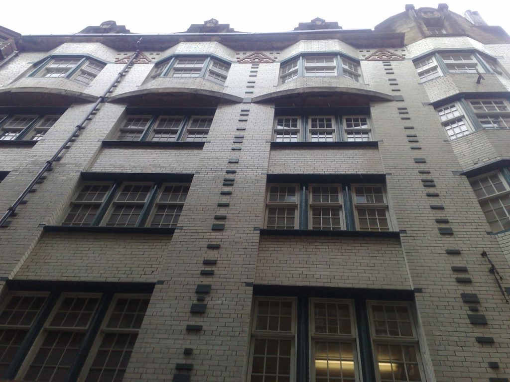 Looking up, a spectacular elevation showing Mackintosh frontage with blue and white glazed tiles 