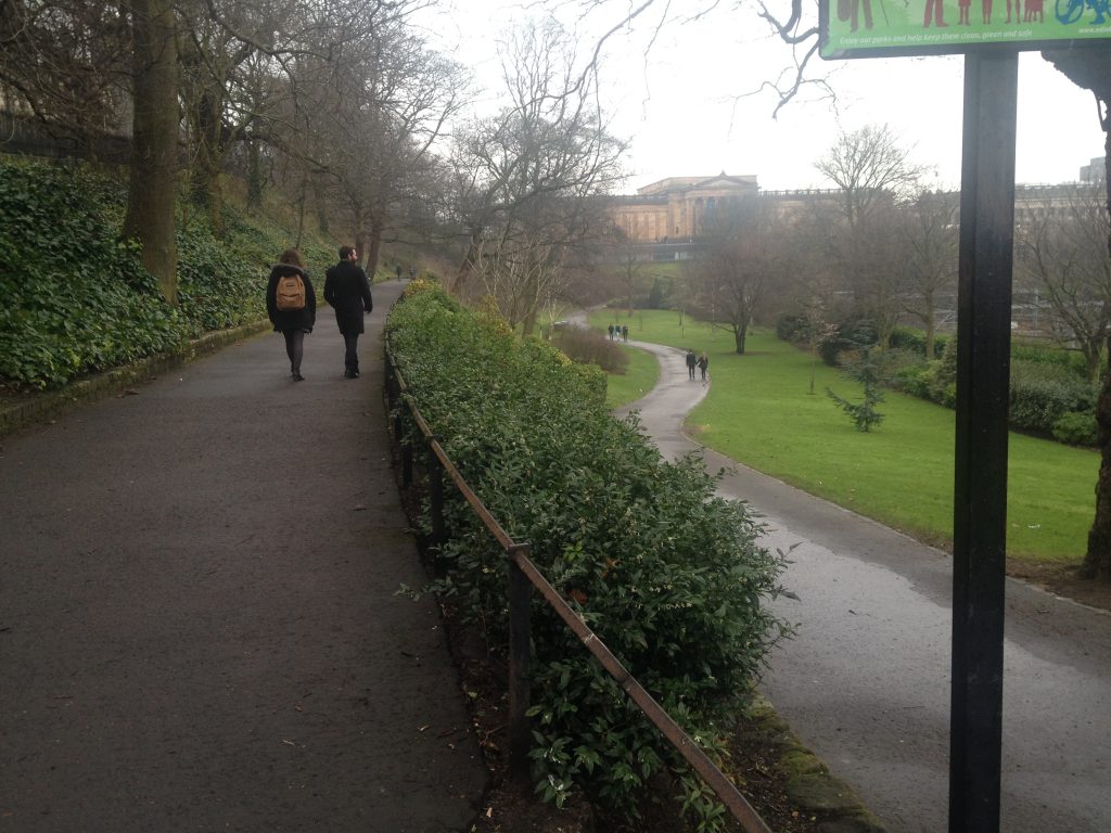 Entrance to Princes Street Gardens, passing a row of modest evergreen shrubs