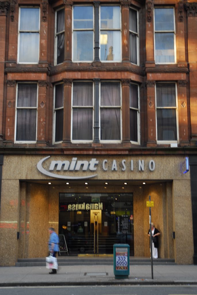 The Mint Casino doorway, a man in a blue shirt walks past