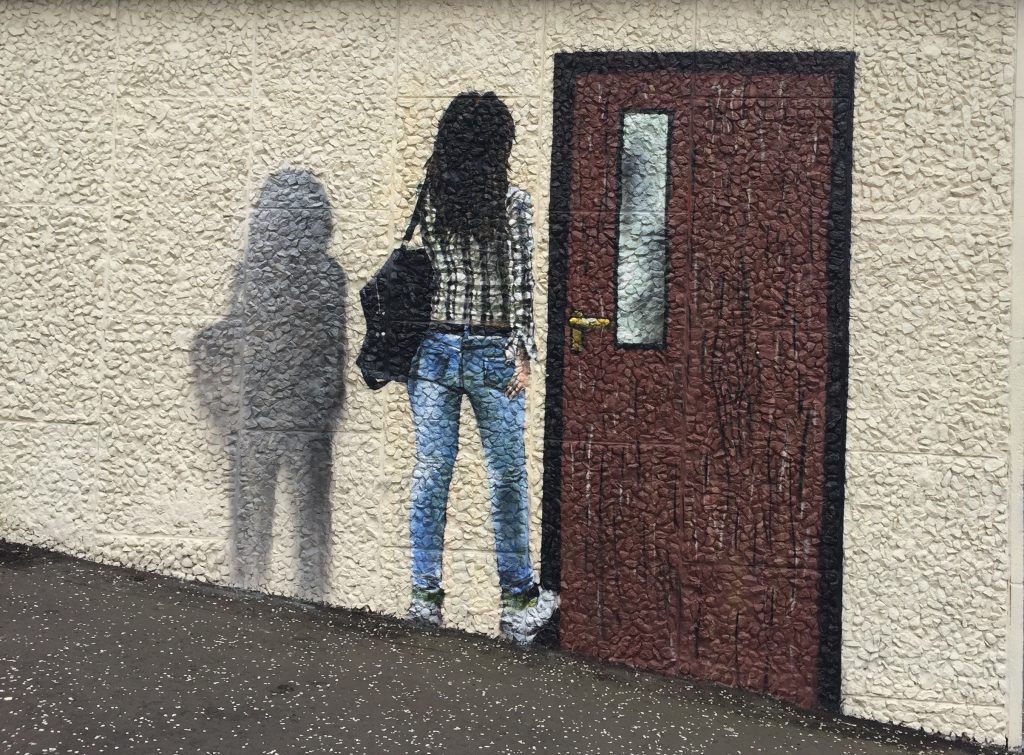 Mural of girl walking through wall