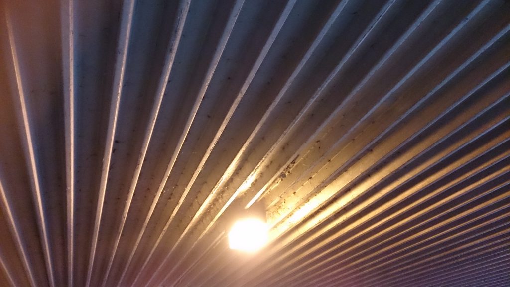 Single light in ribbed metal ceiling