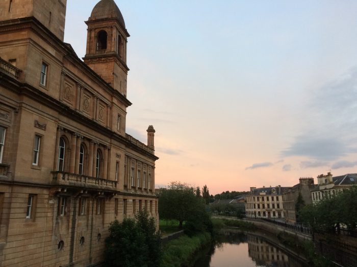 An evocative view of Paisley Town Hall with sunset reflecting in the canal