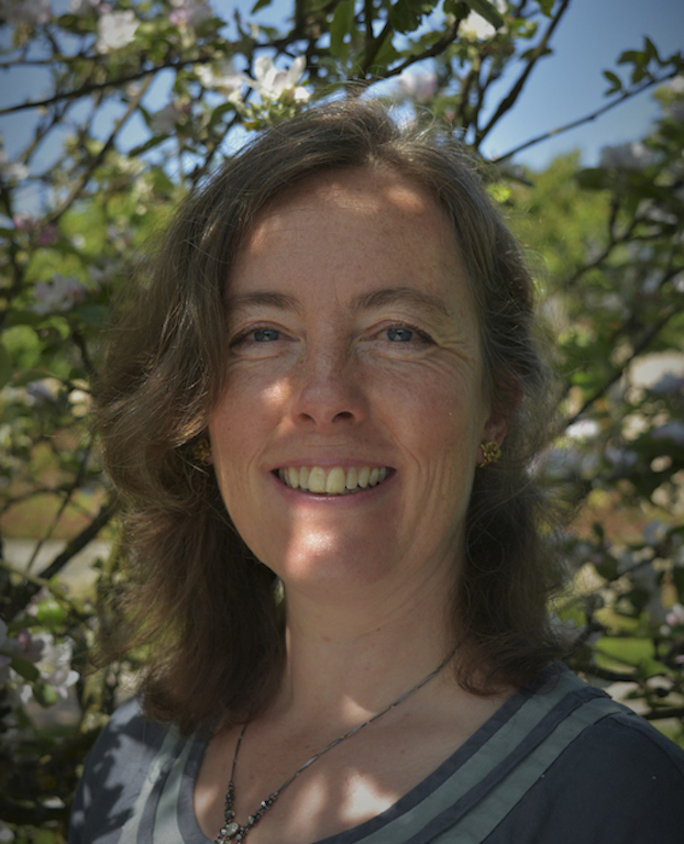 Portrait of Abi Rooley-Towle standing beneath cherry tree in bloom 